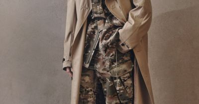 Maskáče v elegantnější společnosti. Značka Co pro Pre-Fall 2026 vrství výrazný camo komplet pod klasický béžový trenčkot a ukazuje, že vojenský vzor může fungovat i v sofistikovaném městském stylingu. Foto: Co, Pre-Fall 2026